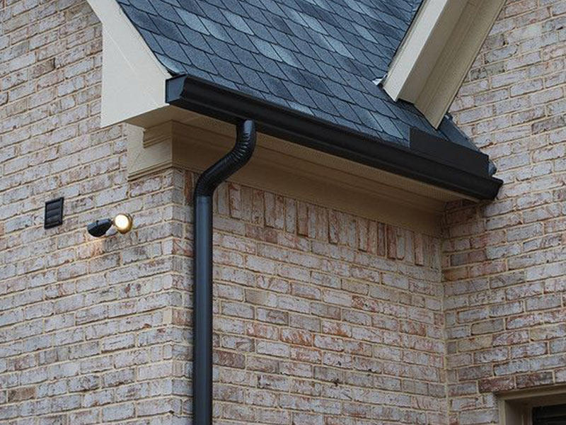 part of brick home with black gutter and rain drain golena mo